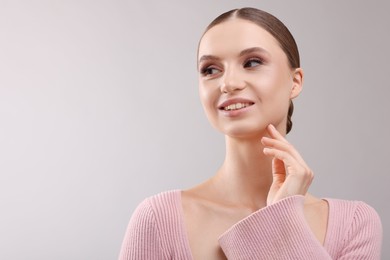 Photo of Portrait of beautiful young woman on gray background, space for text