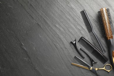 Photo of Different hairdresser's tools on dark table, flat lay. Space for text