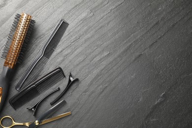 Photo of Different hairdresser's tools on dark table, flat lay. Space for text