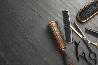 Photo of Different hairdresser's tools on dark table, flat lay. Space for text