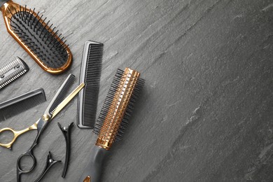 Photo of Different hairdresser's tools on dark table, flat lay. Space for text
