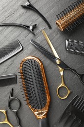Photo of Different hairdresser's tools on dark table, flat lay