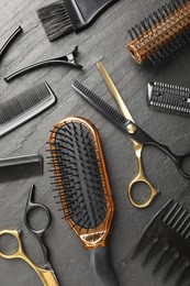 Photo of Different hairdresser's tools on dark table, flat lay