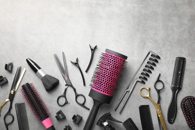 Photo of Different hairdresser's tools on grey table, flat lay. Space for text