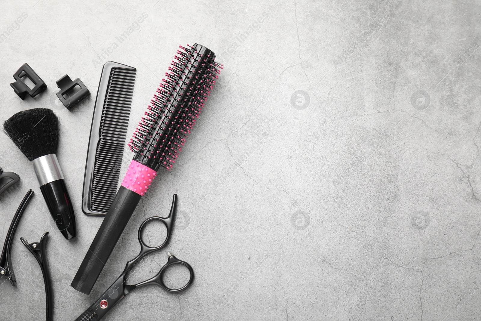 Different hairdresser's tools on grey table, flat lay. Space for text Photo of Different hairdresser's tools on grey table, flat lay. Space for text