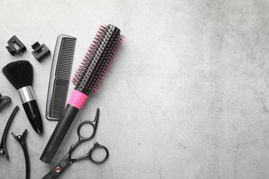 Photo of Different hairdresser's tools on grey table, flat lay. Space for text