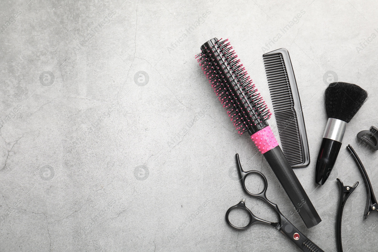 Different hairdresser's tools on grey table, flat lay. Space for text Photo of Different hairdresser's tools on grey table, flat lay. Space for text