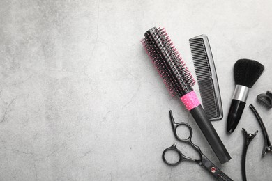 Photo of Different hairdresser's tools on grey table, flat lay. Space for text