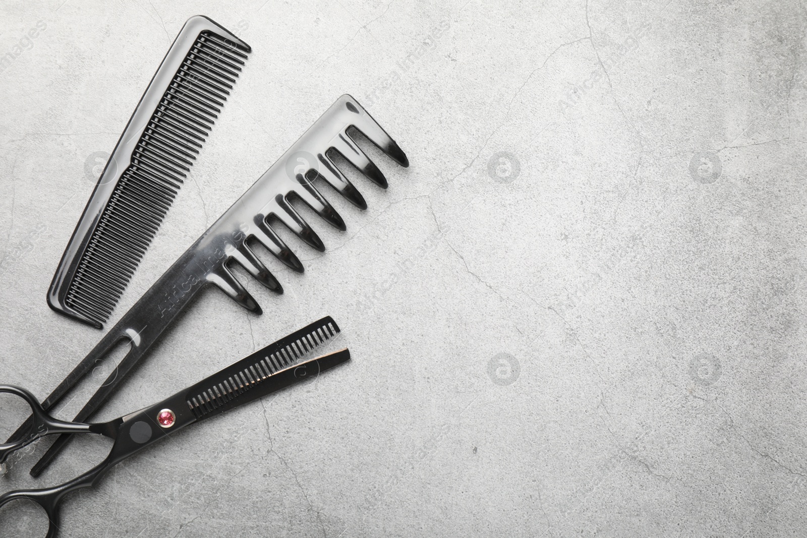 Different hairdresser's tools on grey table, flat lay. Space for text Photo of Different hairdresser's tools on grey table, flat lay. Space for text