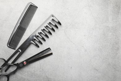 Photo of Different hairdresser's tools on grey table, flat lay. Space for text