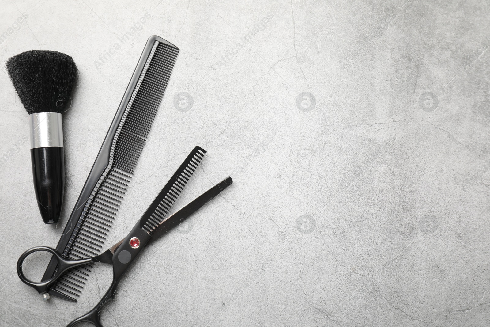 Different hairdresser's tools on grey table, flat lay. Space for text Photo of Different hairdresser's tools on grey table, flat lay. Space for text