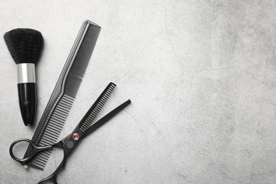 Photo of Different hairdresser's tools on grey table, flat lay. Space for text