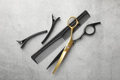 Photo of Different hairdresser's tools on grey table, flat lay