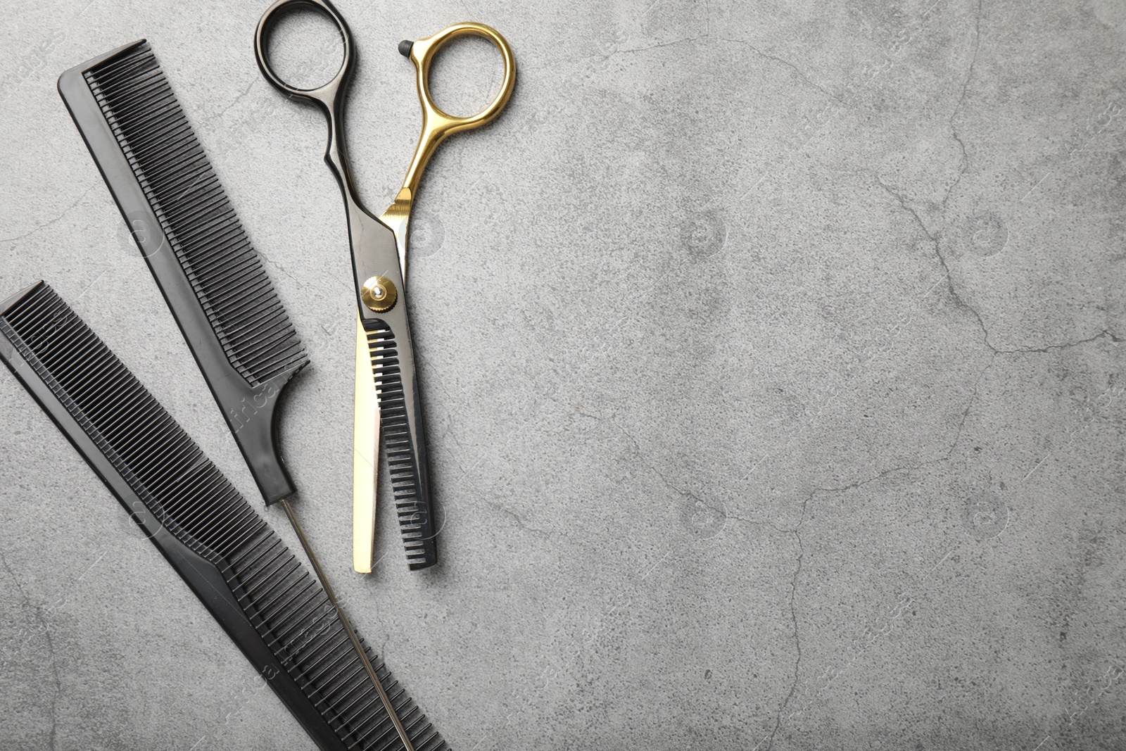 Different hairdresser's tools on grey table, flat lay. Space for text Photo of Different hairdresser's tools on grey table, flat lay. Space for text