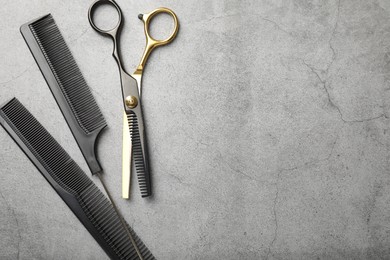 Photo of Different hairdresser's tools on grey table, flat lay. Space for text