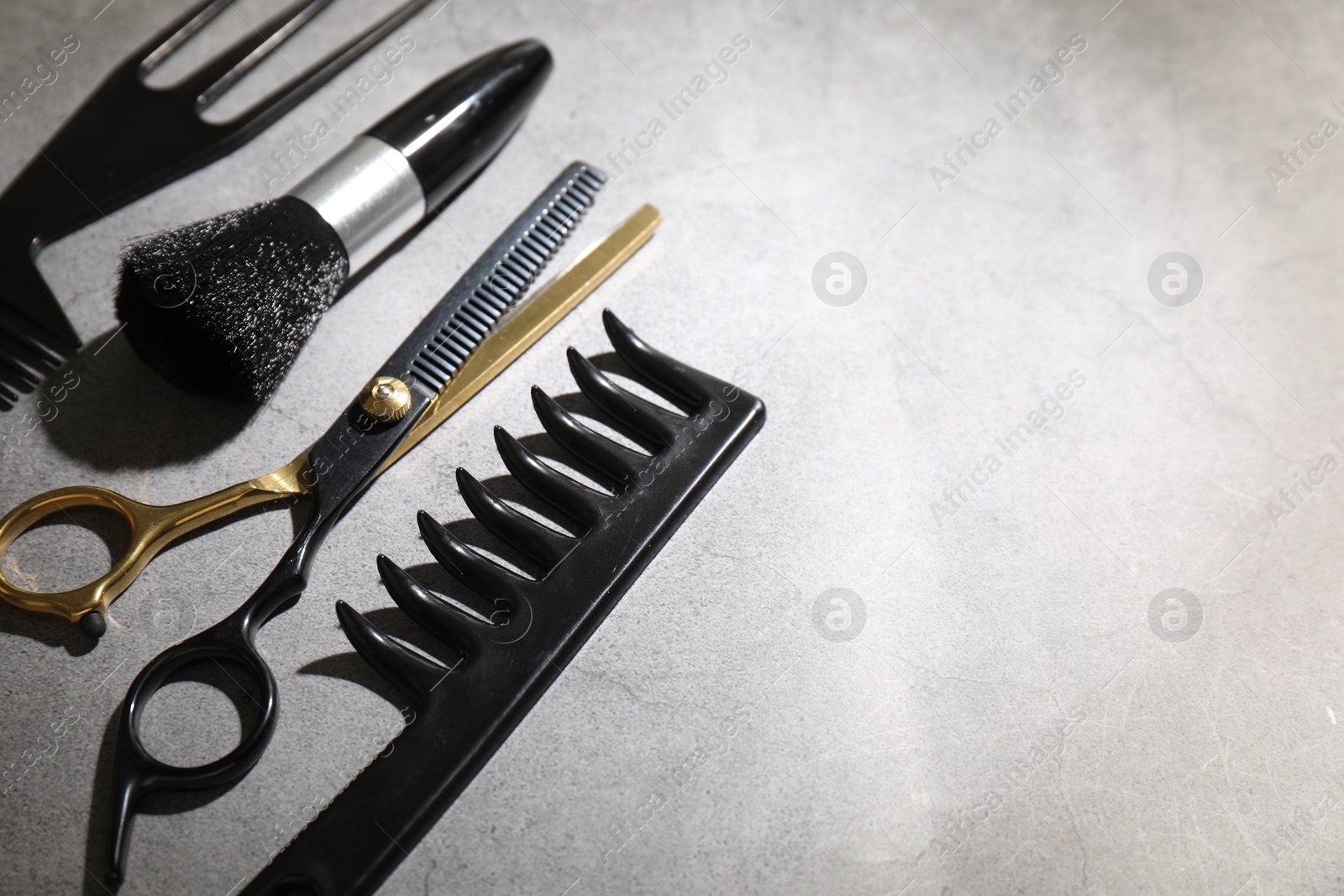Different hairdresser's tools on grey table, closeup. Space for text Photo of Different hairdresser's tools on grey table, closeup. Space for text