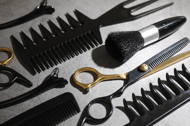 Photo of Different hairdresser's tools on grey table, closeup