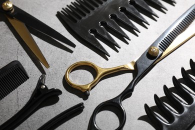 Photo of Different hairdresser's tools on grey table, closeup