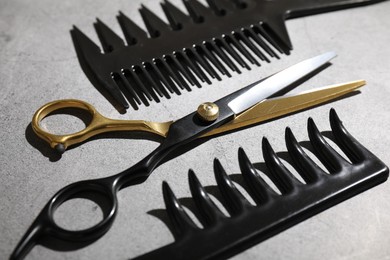 Photo of Different hairdresser's tools on grey table, closeup
