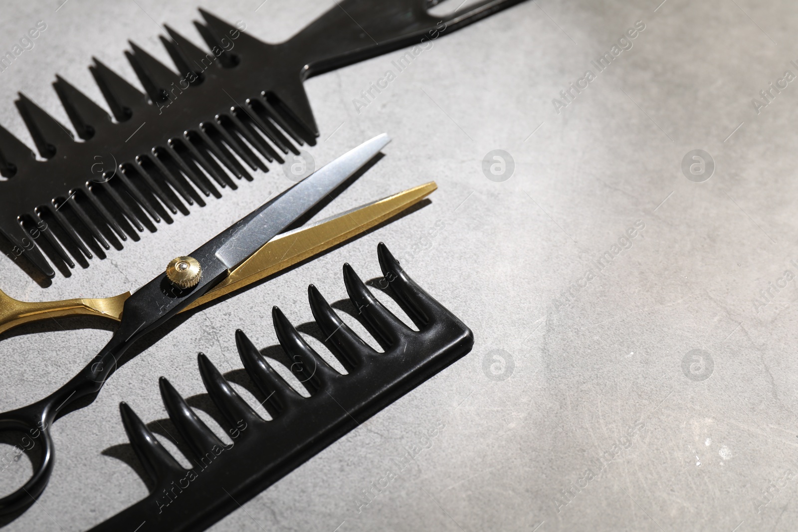 Different hairdresser's tools on grey table, closeup. Space for text Photo of Different hairdresser's tools on grey table, closeup. Space for text