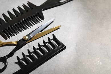 Photo of Different hairdresser's tools on grey table, closeup. Space for text