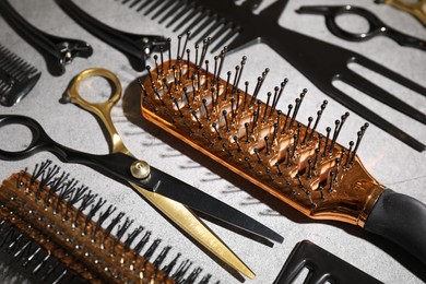 Photo of Different hairdresser's tools on grey table, closeup