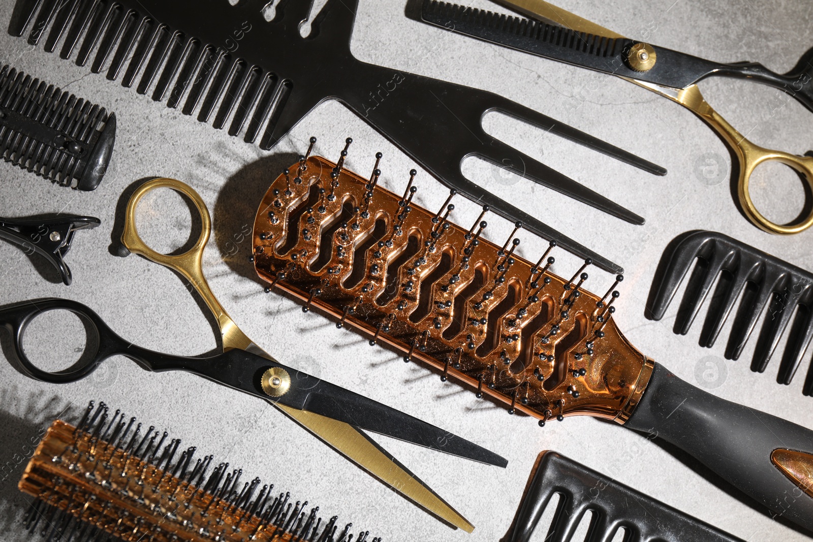 Different hairdresser's tools on grey table, flat lay Photo of Different hairdresser's tools on grey table, flat lay