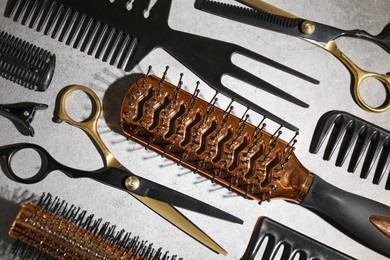 Photo of Different hairdresser's tools on grey table, flat lay