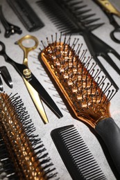Photo of Different hairdresser's tools on grey table, closeup