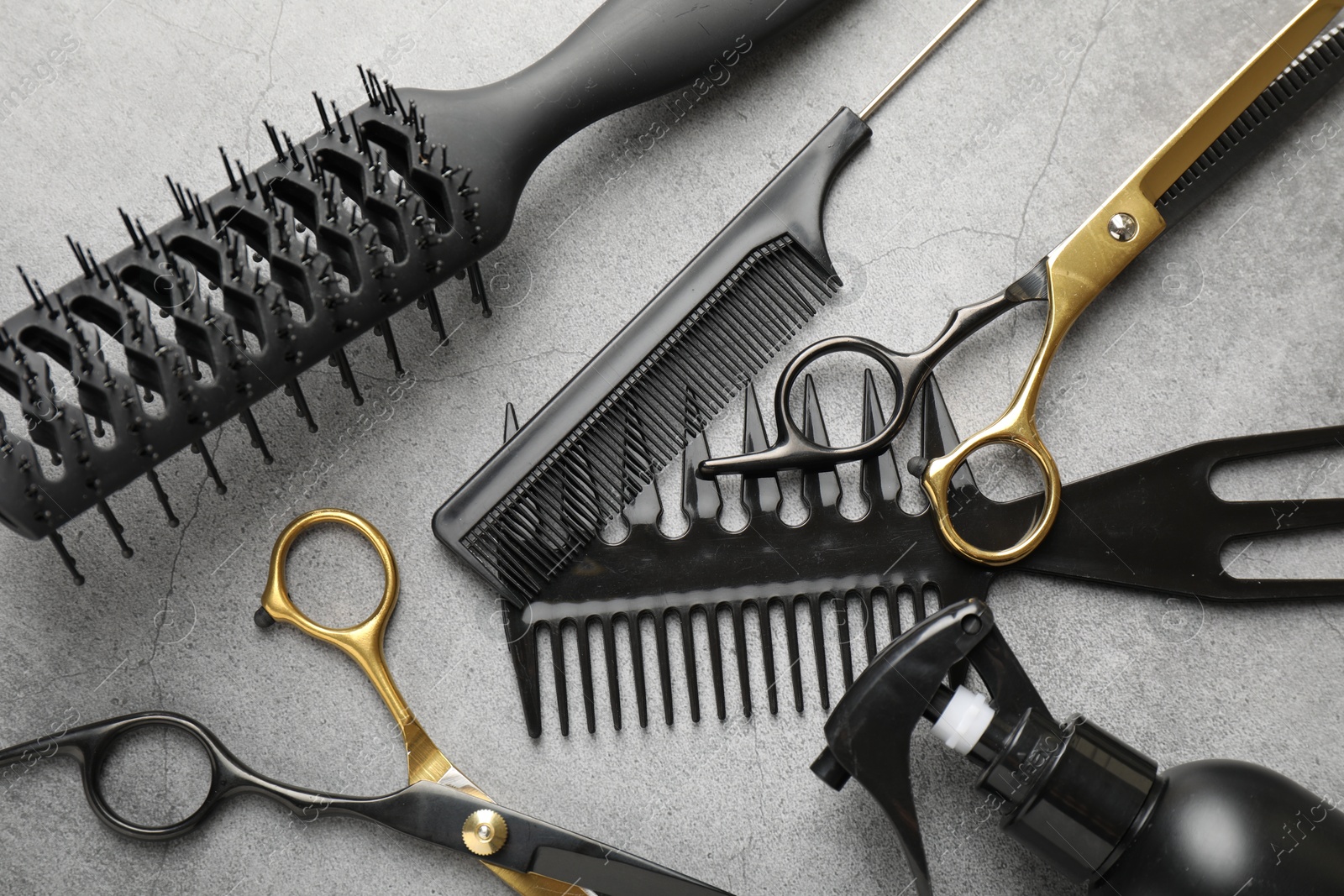 Different hairdresser's tools on grey table, flat lay Photo of Different hairdresser's tools on grey table, flat lay