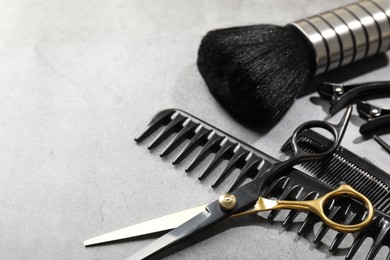 Photo of Different hairdresser's tools on grey table, closeup. Space for text