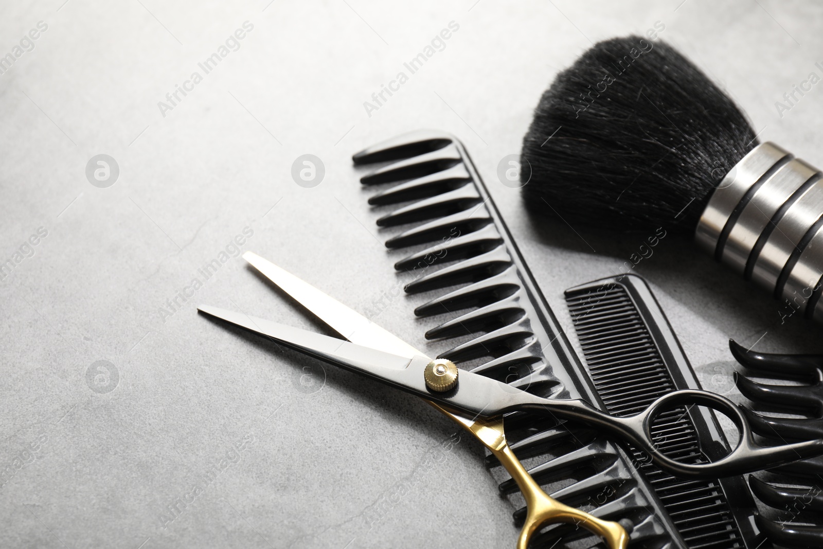 Different hairdresser's tools on grey table, closeup. Space for text Photo of Different hairdresser's tools on grey table, closeup. Space for text