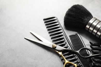 Photo of Different hairdresser's tools on grey table, closeup. Space for text