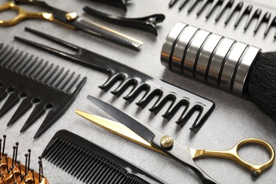 Photo of Different hairdresser's tools on grey table, closeup