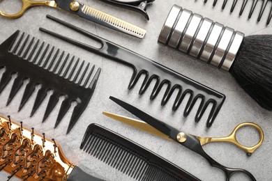 Photo of Different hairdresser's tools on grey table, flat lay