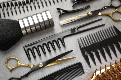 Photo of Different hairdresser's tools on grey table, flat lay