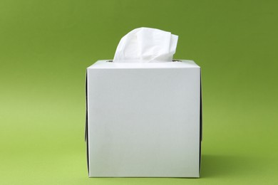 Photo of Box with paper handkerchiefs on green background