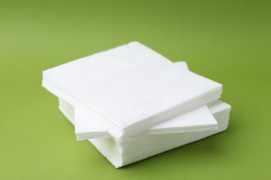 Photo of Stack of white handkerchiefs on green background, closeup