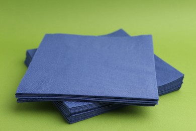 Photo of Stack of blue handkerchiefs on green background, closeup