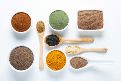 Photo of Different superfood powders in bowls and spoons on white background, flat lay