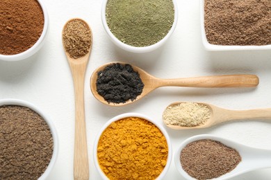 Photo of Different superfood powders in bowls and spoons on white background, flat lay