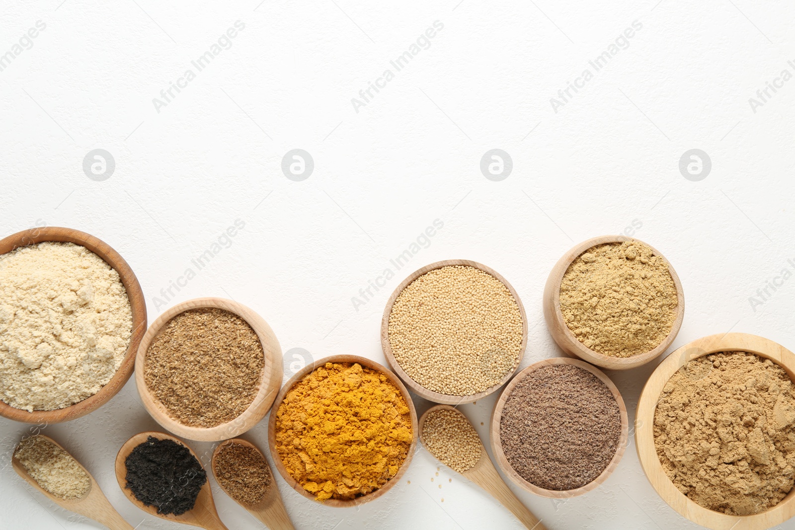 Different superfood powders in bowls and spoons on white background, flat lay. Space for text Photo of Different superfood powders in bowls and spoons on white background, flat lay. Space for text