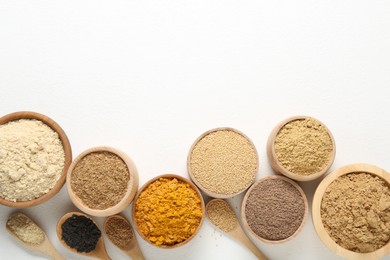 Photo of Different superfood powders in bowls and spoons on white background, flat lay. Space for text