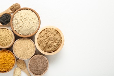 Photo of Different superfood powders in bowls and spoons on white background, flat lay. Space for text