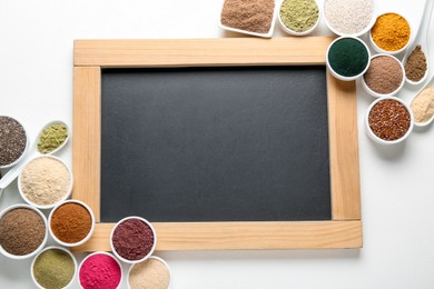 Photo of Different superfood products and blank chalkboard on white background, flat lay. Space for text