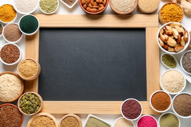 Photo of Different superfood products and blank chalkboard on white background, flat lay. Space for text