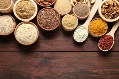 Photo of Different superfood products on wooden table, flat lay. Space for text