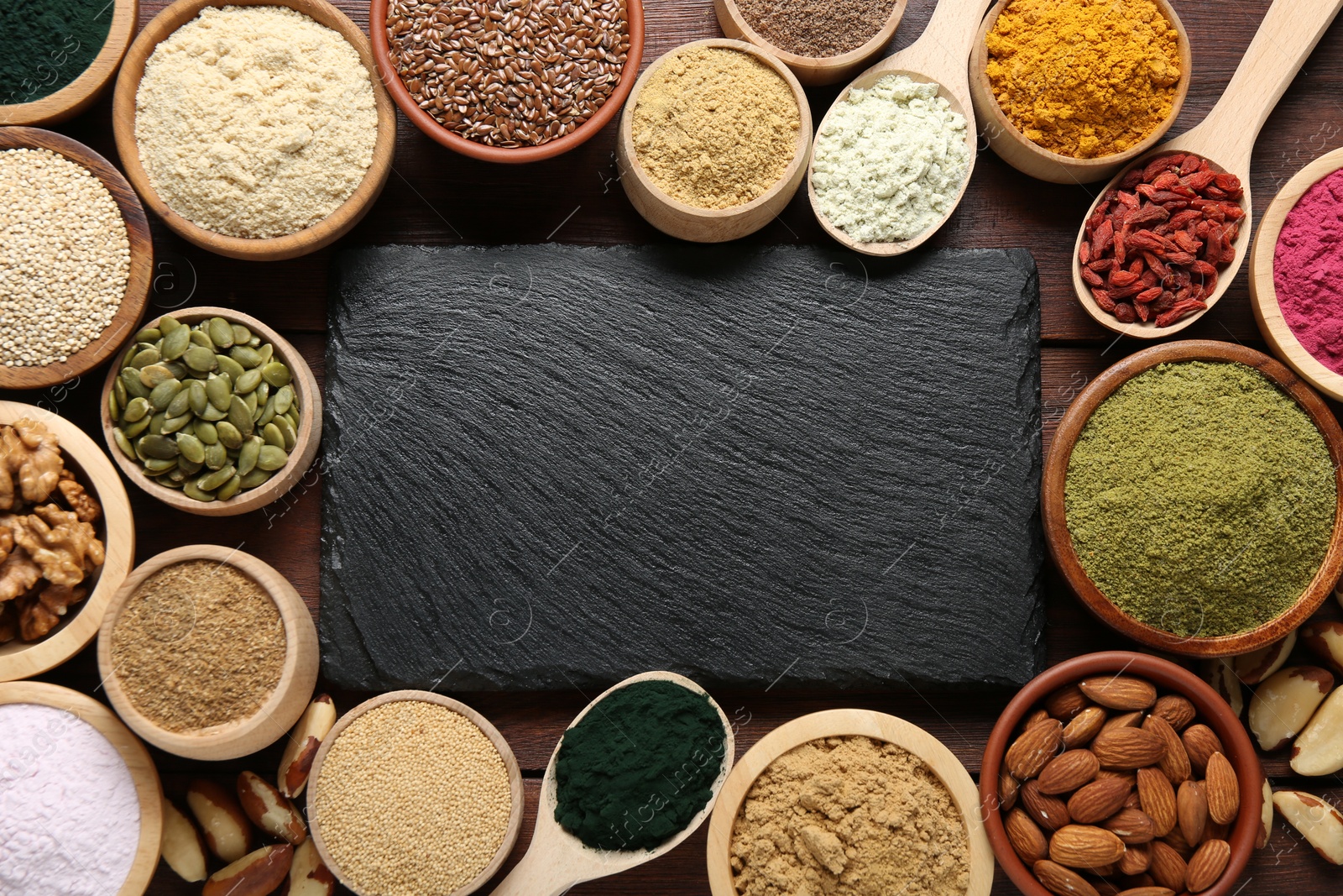 Different superfood products and blank board on wooden table, flat lay. Space for text Photo of Different superfood products and blank board on wooden table, flat lay. Space for text