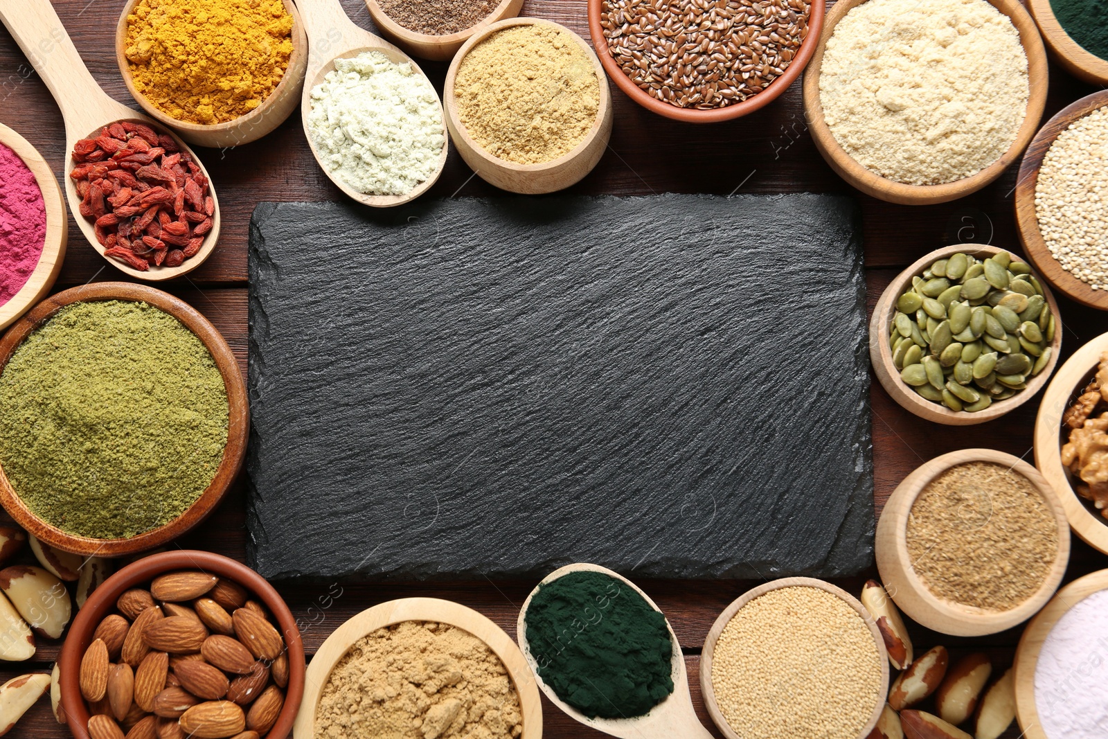 Different superfood products and blank board on wooden table, flat lay. Space for text Photo of Different superfood products and blank board on wooden table, flat lay. Space for text