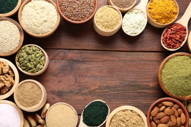 Photo of Frame of different superfood products on wooden table, flat lay. Space for text